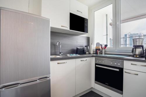 a kitchen with white cabinets and a sink at Ferienwohnung Ausblick in Bremerhaven