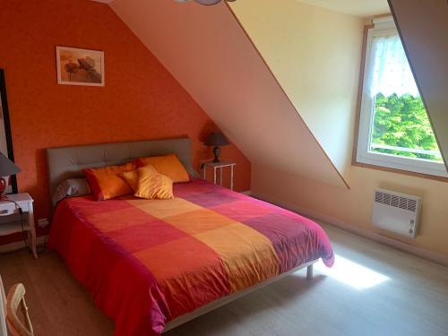 1 dormitorio con 1 cama con pared de color naranja en Chambre D'Hote, en Roz-Landrieux
