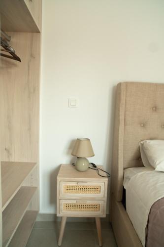 a lamp on a night stand next to a bed at Hello Village Chania in SFakianalíon
