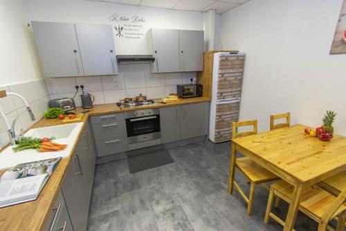 kuchnia z drewnianym stołem i stołem oraz drewnianym stołem w obiekcie CADeS accommodation w mieście Wolverhampton