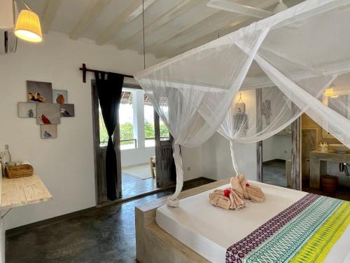 a bedroom with a bed with a canopy at Villa Huruma in Paje