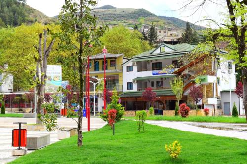 a building in the middle of a green park at Hotel Osumi in Çorovodë