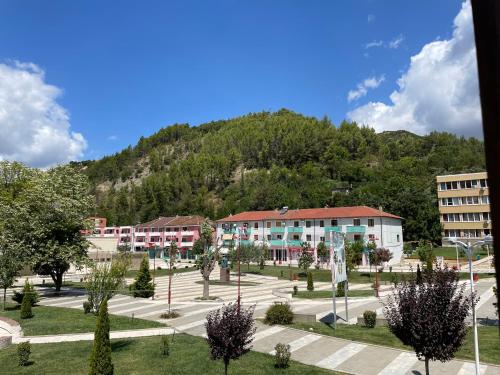 a group of buildings in front of a mountain at Hotel Osumi in Çorovodë