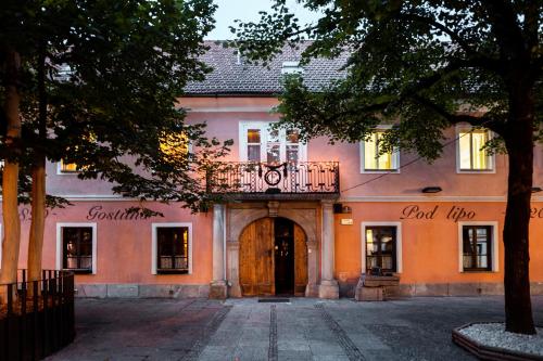 a pink building with a door and a balcony at Penzion Pod Lipo in Ljubljana