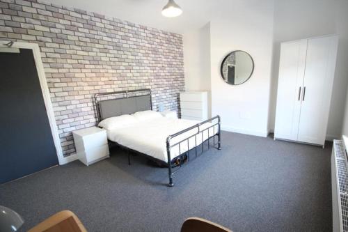 una camera con letto e muro di mattoni di 204 Uttoxeter Old Road a Derby