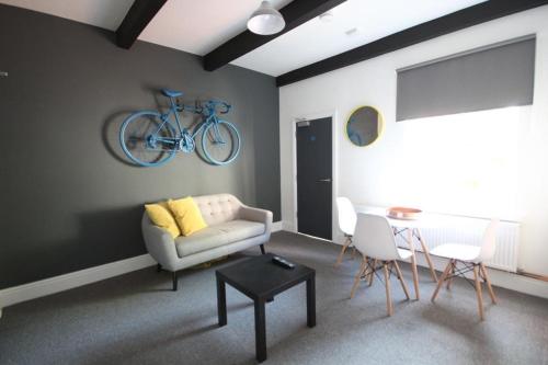 un soggiorno con divano e una bicicletta appesa al muro di 204 Uttoxeter Old Road a Derby
