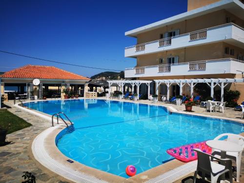a large swimming pool in front of a hotel at Nafsika Hotel in Agios Stefanos