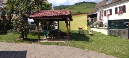 a gazebo with a table and chairs in a yard at Gîte Yves in Wihr-au-Val