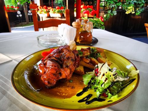 a plate of food with meat and vegetables on a table at Crama Haiducilor in Cluj-Napoca