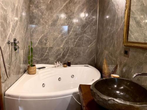 a bathroom with a bath tub and a sink at Sole apartment in Taormina