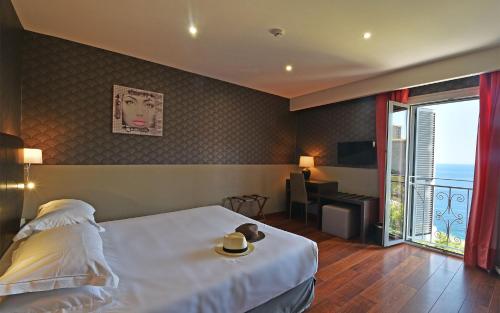 a hotel room with a bed and a balcony at Hotel Restaurant Christophe Colomb in Calvi