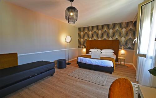 a bedroom with a bed and a couch at Hotel Restaurant Christophe Colomb in Calvi