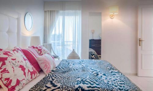 ラ・カラ・デ・ミハスにあるSea View apartment in posh Mirafloresのベッドルーム(青と白のベッド1台、窓付)