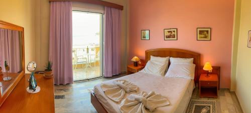 a bedroom with a bed and a large window at Nafsika Hotel in Agios Stefanos
