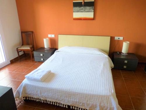 a bedroom with a large white bed with two night stands at Hort de la Cinteta in Alcover