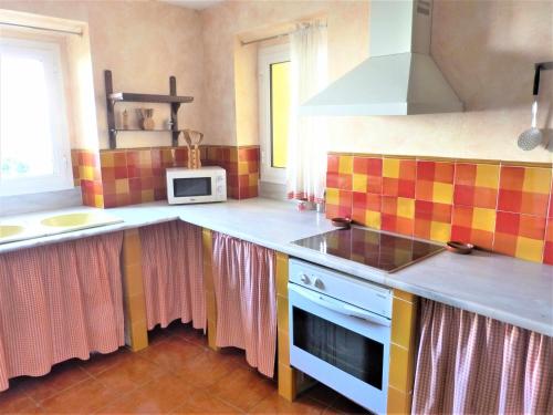 a kitchen with a sink and a stove top oven at Hort de la Cinteta in Alcover