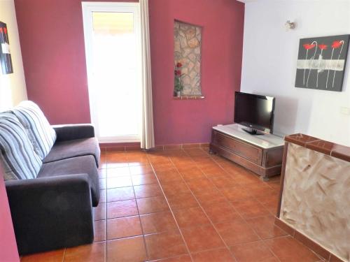 a living room with a couch and a tv at Hort de la Cinteta in Alcover
