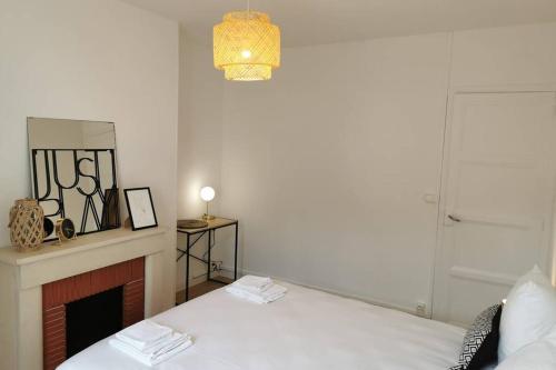 a white room with a bed and a fireplace at Le LORENZO - hypercentre, cosy et vue Loire in Blois