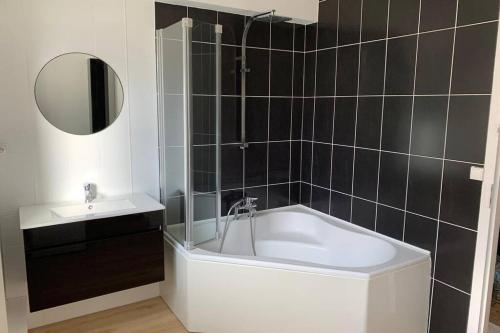 une salle de bain avec une baignoire, un lavabo et un miroir dans l'établissement Le LORENZO - hypercentre, cosy et vue Loire, à Blois