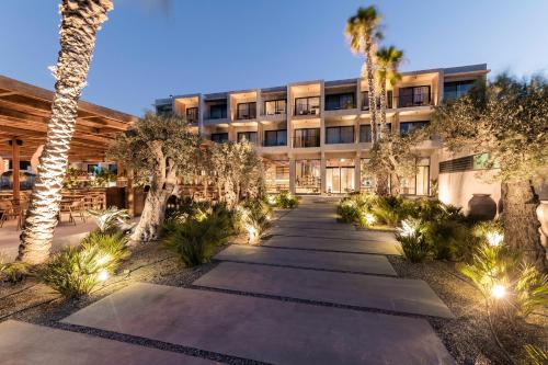 an exterior view of a building with palm trees and lights at Lindos Aqua Terra in Líndos