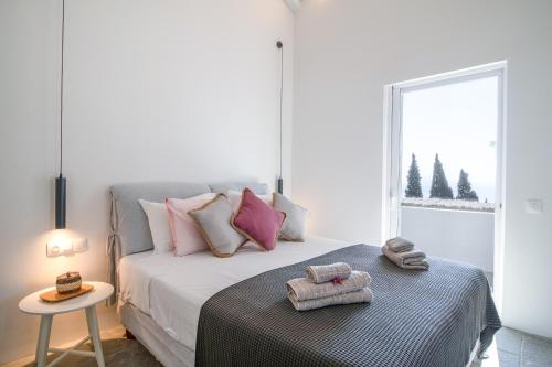 um quarto com uma cama com almofadas cor-de-rosa e uma janela em Zoela Corfu - 2 Seperate Houses With Full Privacy em Gastouri