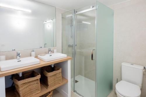 une salle de bain avec deux lavabos et une douche en verre dans l'établissement La Cala Malmousque - Magnifique petite maison au bord de l'eau, à Marseille
