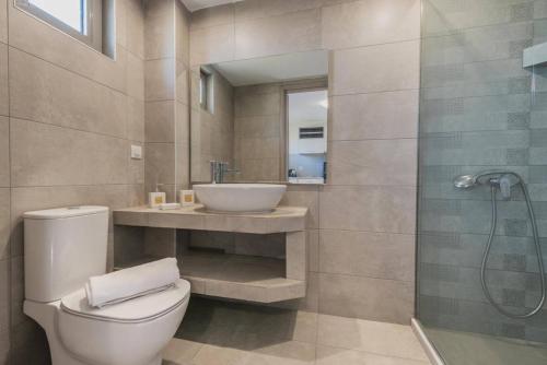 a bathroom with a toilet and a sink and a shower at Casa 77 Zante by Karras Hotels in Zakynthos Town