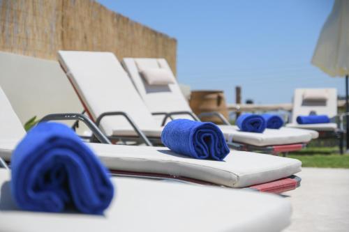 une rangée de chaises longues vides avec poignées bleues dans l'établissement Arismari Villa - Heated Private Pool, à episkopi-heraklion