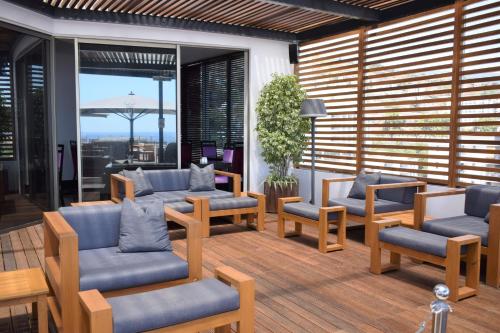a patio with couches and chairs on a deck at Madeira Regency Cliff - Adults Only in Funchal