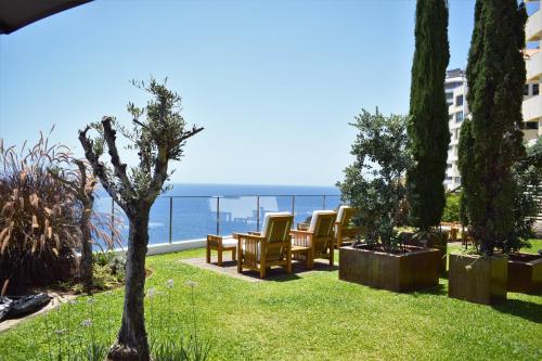 豐沙爾的住宿－Madeira Regency Cliff - Adults Only，一个带椅子的花园,享有海景