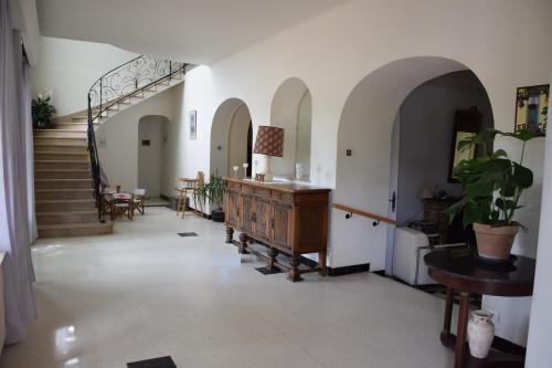 a hallway with a staircase and a desk in a building at Villa de l'Agapé - Drome provencale - 7 ch - 10 à 24 personnes - 350m2 in Tulette