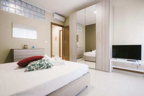 トリエステにあるGrab a Flat in Coroneoの白いベッドルーム(大型ベッド1台、テレビ付)
