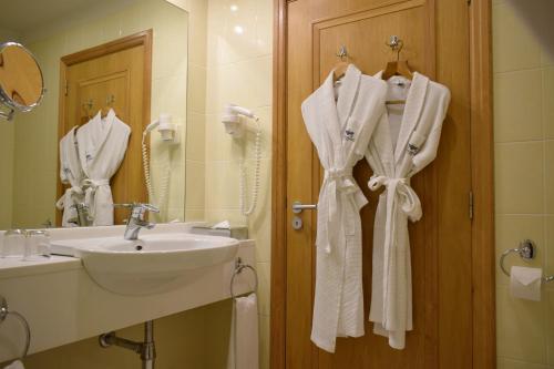 a bathroom with a sink and a mirror and towels at Madeira Regency Cliff - Adults Only in Funchal
