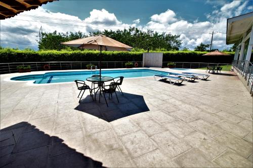 a patio with a table and chairs next to a pool at Amazilia Hotel in Pereira