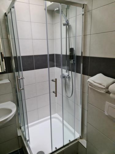 La salle de bains est pourvue d'une douche avec une porte en verre. dans l'établissement Shop 23, à Hambourg