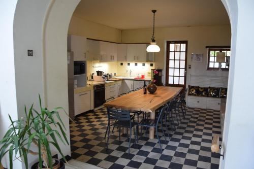 a large kitchen with a wooden table and chairs at Villa de l'Agapé - Drome provencale - 7 ch - 10 à 24 personnes - 350m2 in Tulette
