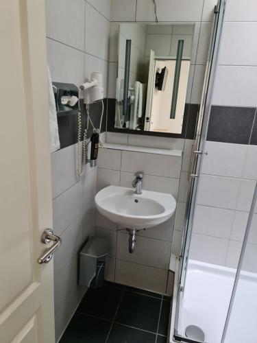 La petite salle de bains est pourvue d'un lavabo et d'un miroir. dans l'établissement Shop 23, à Hambourg