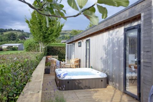 a hot tub on the deck of a house at The Willows, Strawberryfield Park in Cheddar