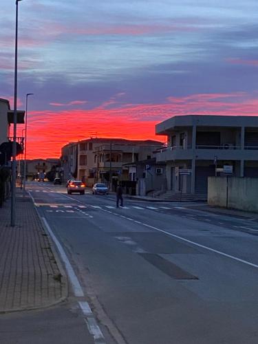eine Stadtstraße mit einem roten Sonnenuntergang am Himmel in der Unterkunft B&B Tequila in Olbia