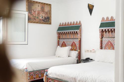 Cette chambre comprend 2 lits et une photo murale. dans l'établissement Hotel Moroccan House Casablanca, à Casablanca