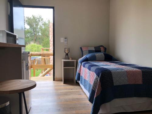 a bedroom with a bed and a door to a deck at LAS ESTEÑAS , casas del mar in La Pedrera