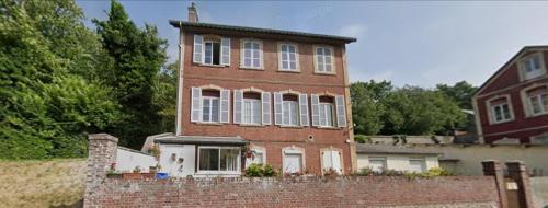 une ancienne maison en briques avec un mur en briques dans l'établissement Appartements a 5 minutes de la mer a pied, à Étretat