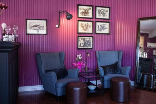 two chairs and a mirror in a room with pink walls at Hotel Leiria Classic in Leiria