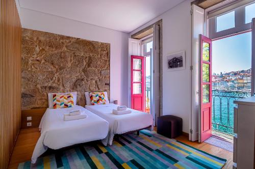 een slaapkamer met 2 bedden en een groot raam bij NorteSoul Porto à Vista in Vila Nova de Gaia