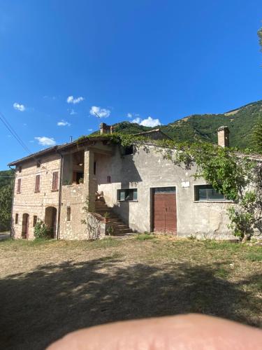una vecchia casa con viti che crescono sul tetto di Casale nella campagna umbra a Costacciaro