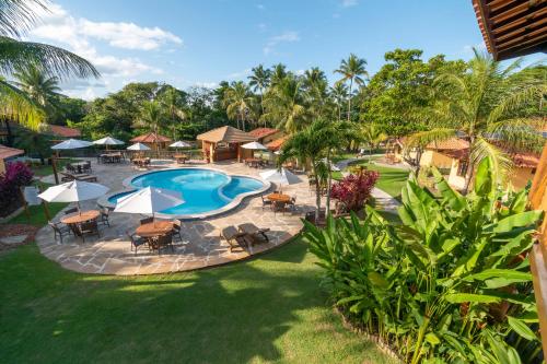 een luchtzicht op een zwembad van het resort met tafels en stoelen bij Hotel Pousada Imbassai in Imbassai