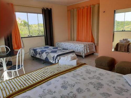 a hotel room with two beds and a window at Sobre as Pedras Chalés in Monte das Gameleiras