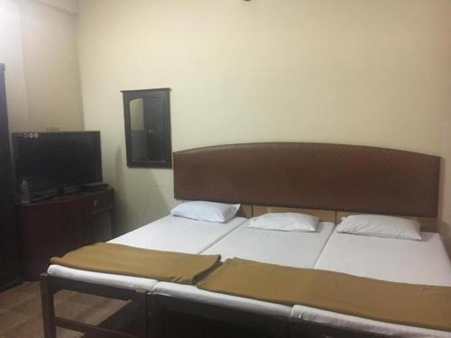 a bedroom with a bed and a flat screen tv at Anupam Residency in Cochin