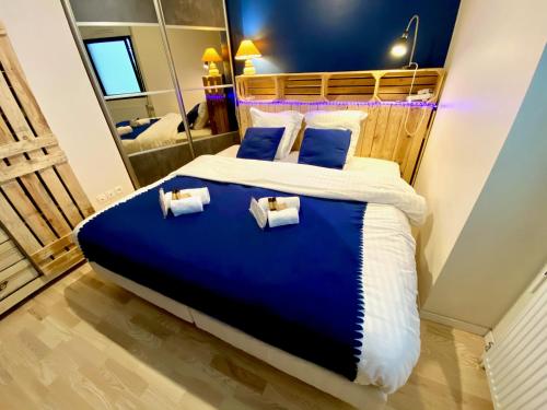 une chambre avec un grand lit avec deux oreillers dans l'établissement Le Neptune, appartement avec parking et jardin proche université, à Caen