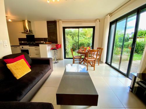 un salon avec un canapé et une table dans l'établissement Le Neptune, appartement avec parking et jardin proche université, à Caen